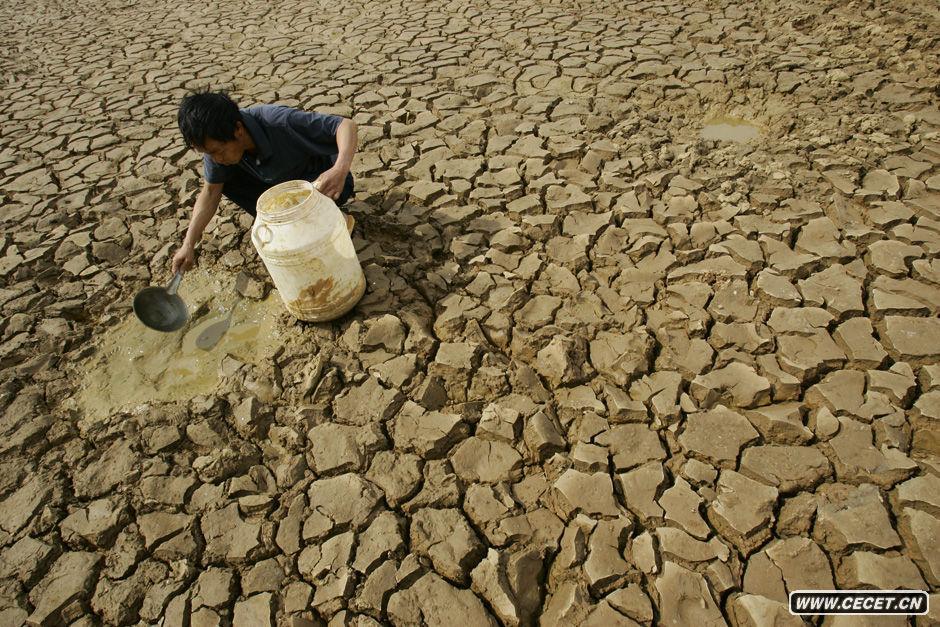 2010年3月4日,云南省文山州广南县珠琳镇,库容量原达到100万方的松树坡小(一)型水库已经几乎干涸,一名农户在库底汲取仅剩的一点塘水。 (图2)