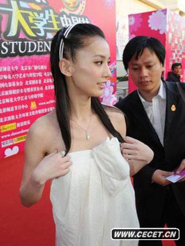 2008年,黄圣依作为颁奖嘉宾出席在北京举办的大学生电影节闭幕颁奖。在红毯上,黄圣依的抹胸裙频频下滑,身旁的男子也因此获得艳福。 (16/16)